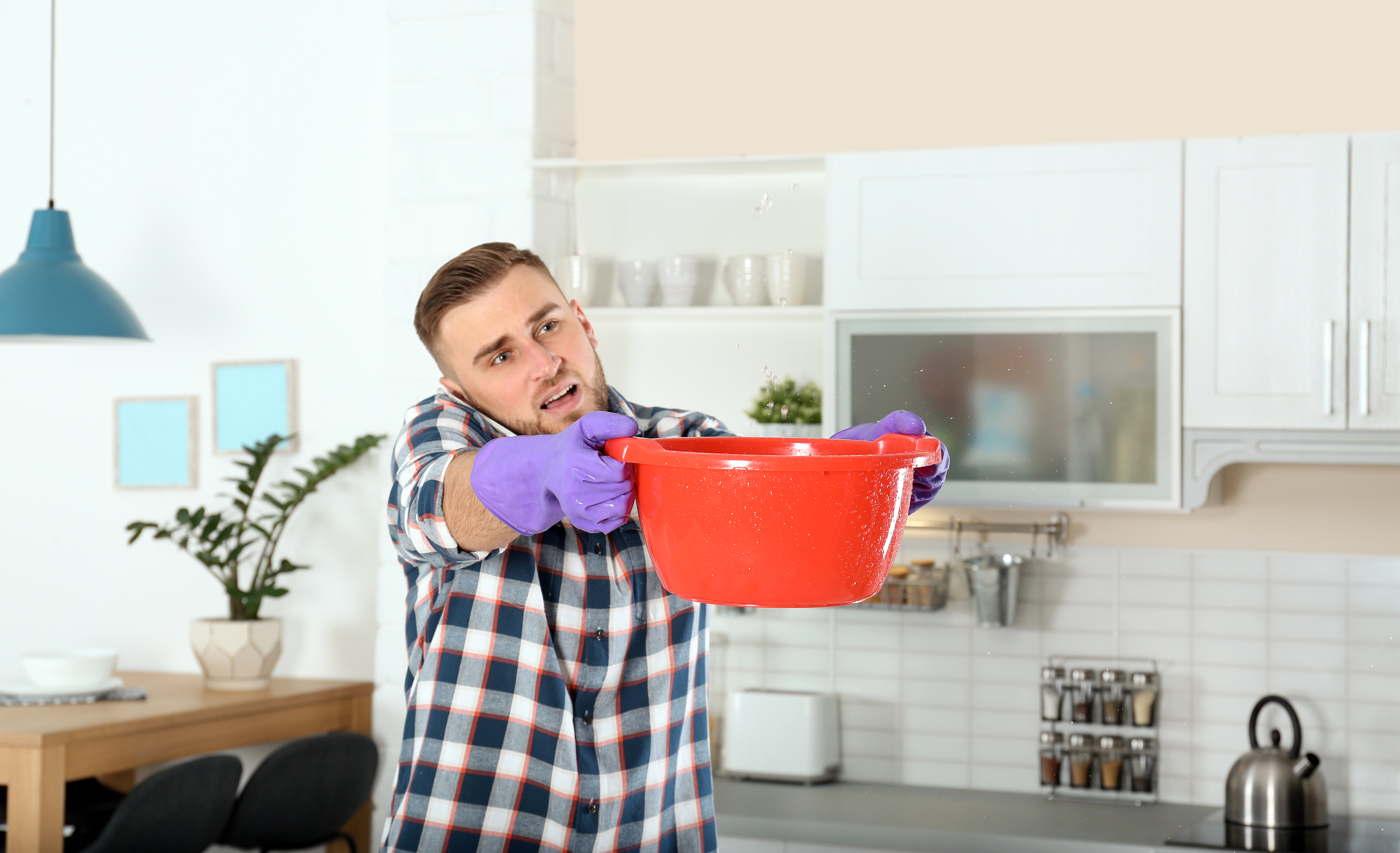 Houston homeowner catching burst pipe water leak in kitchen ceiling